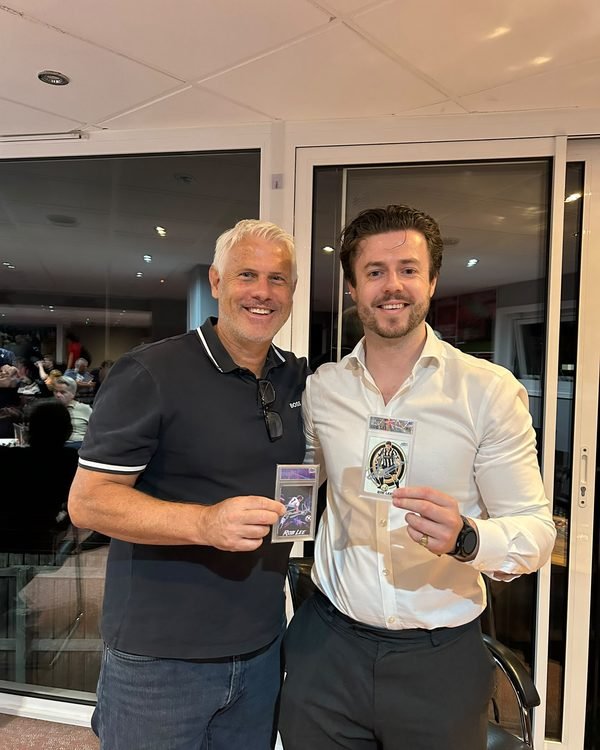 Two people indoors at a club event, each holding a signed Rob Lee Made By Stories slab